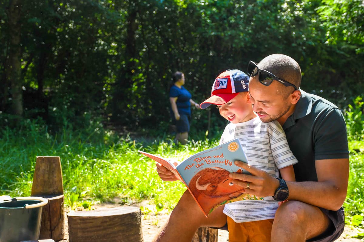 A man reading a book to a little boy