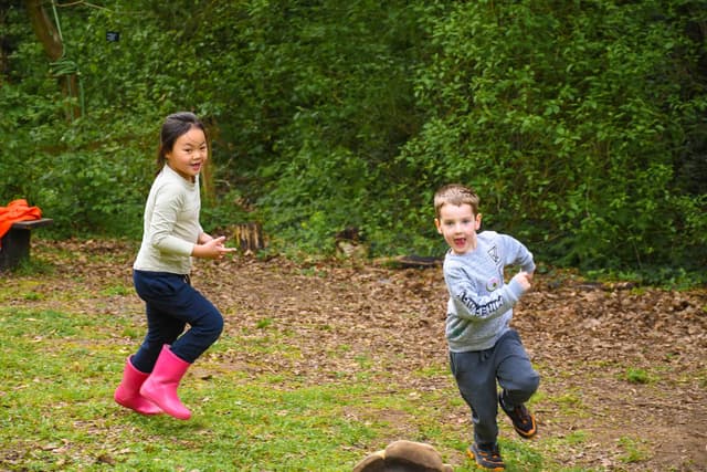 A couple of kids running across a field