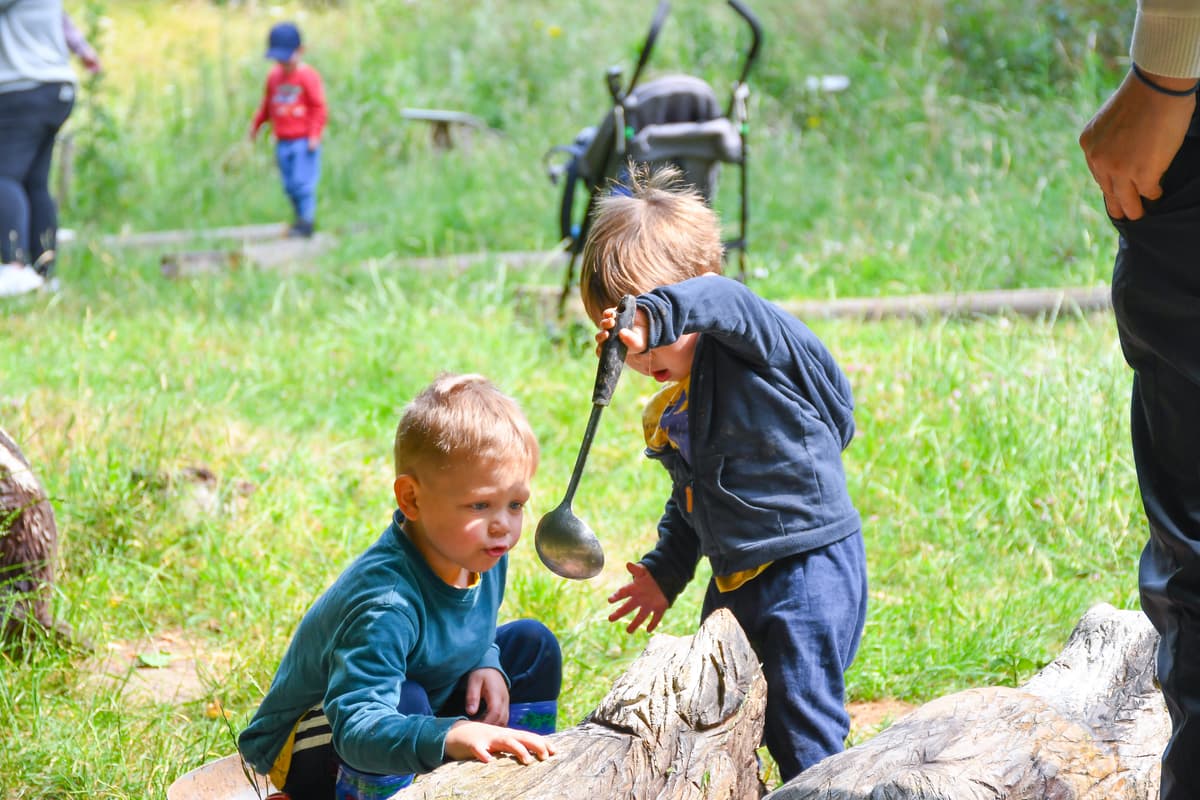 Two young boys playing with a ball in a field