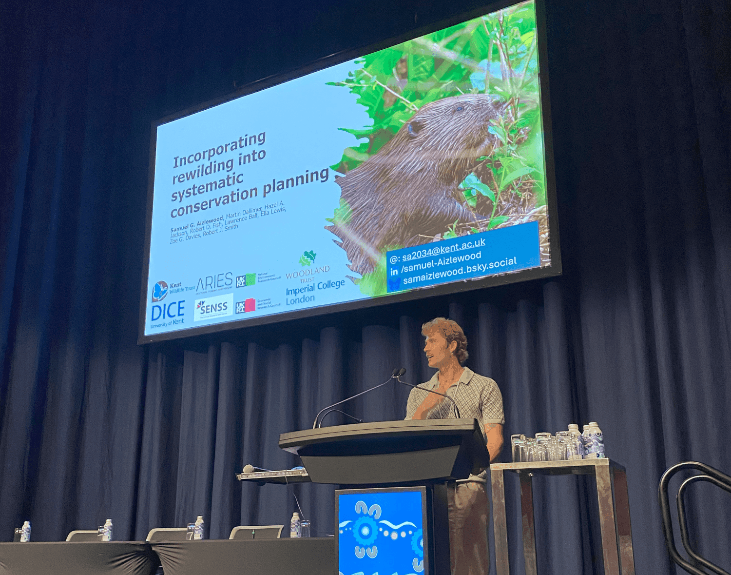 A man standing at a podium in front of a screen