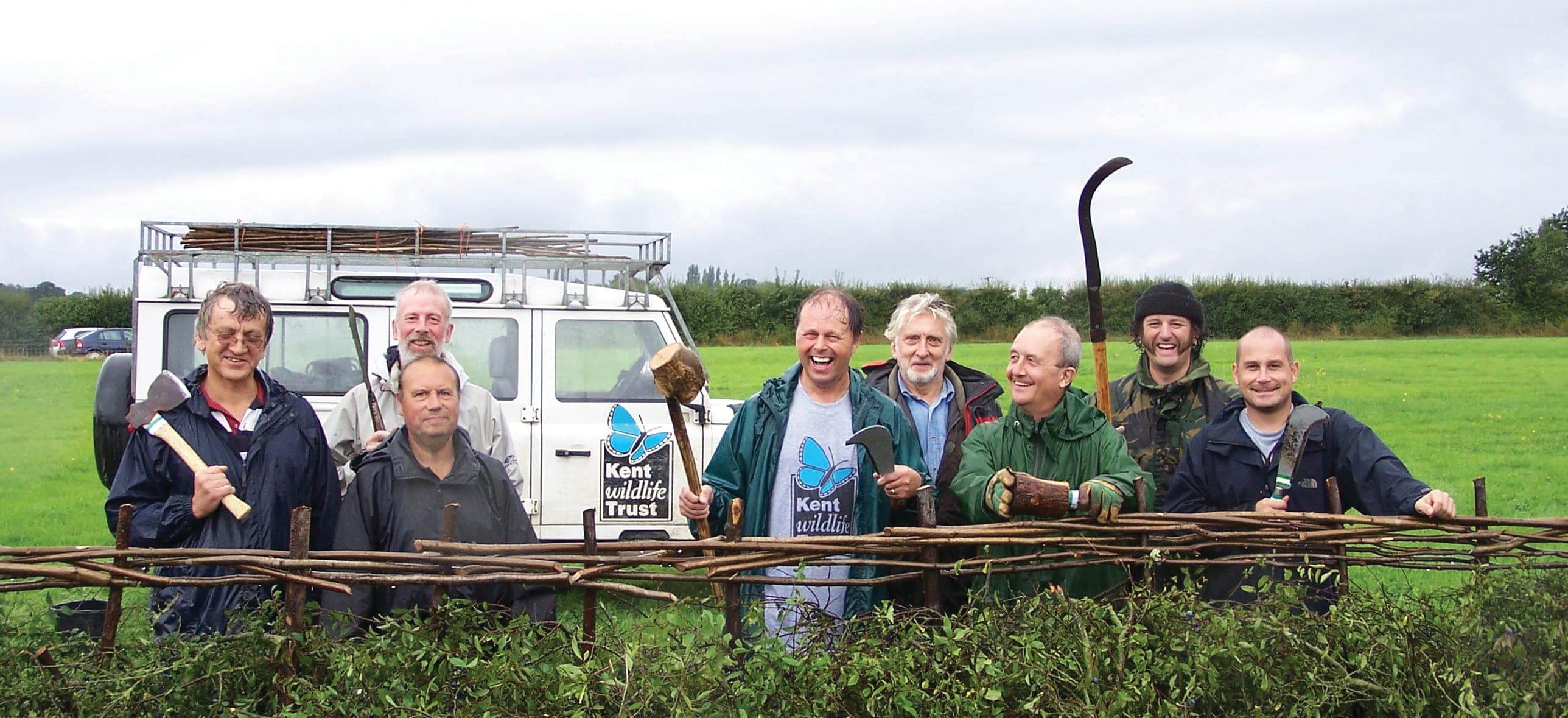 A group of men standing next to each other in front of a truck