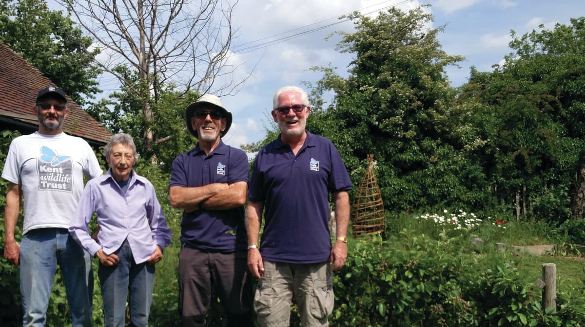A group of men standing next to each other on a lush green field