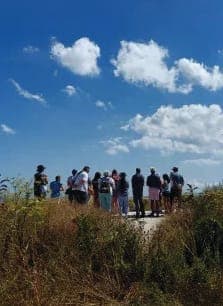 A group of people standing on top of a dirt road
