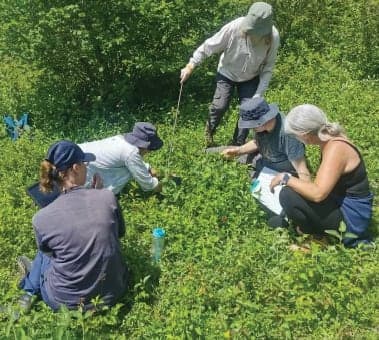 A group of people kneeling down in a field