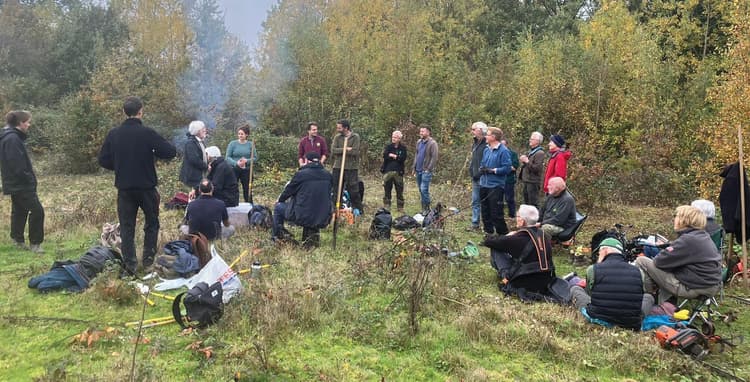 A group of people standing around in a field