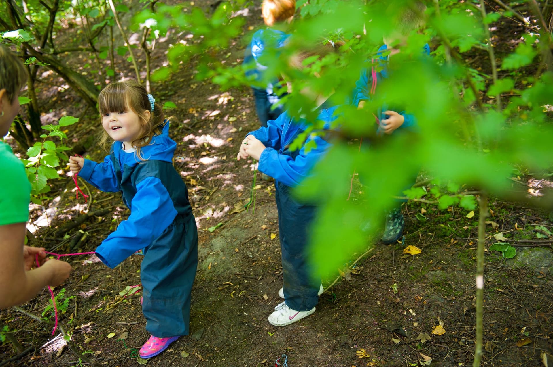 A woman and a little girl walking through a forest