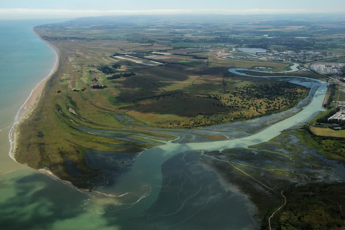 An aerial view of a river running through a lush green field