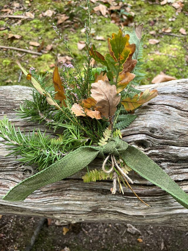 A bouquet of flowers sitting on top of a wooden bench