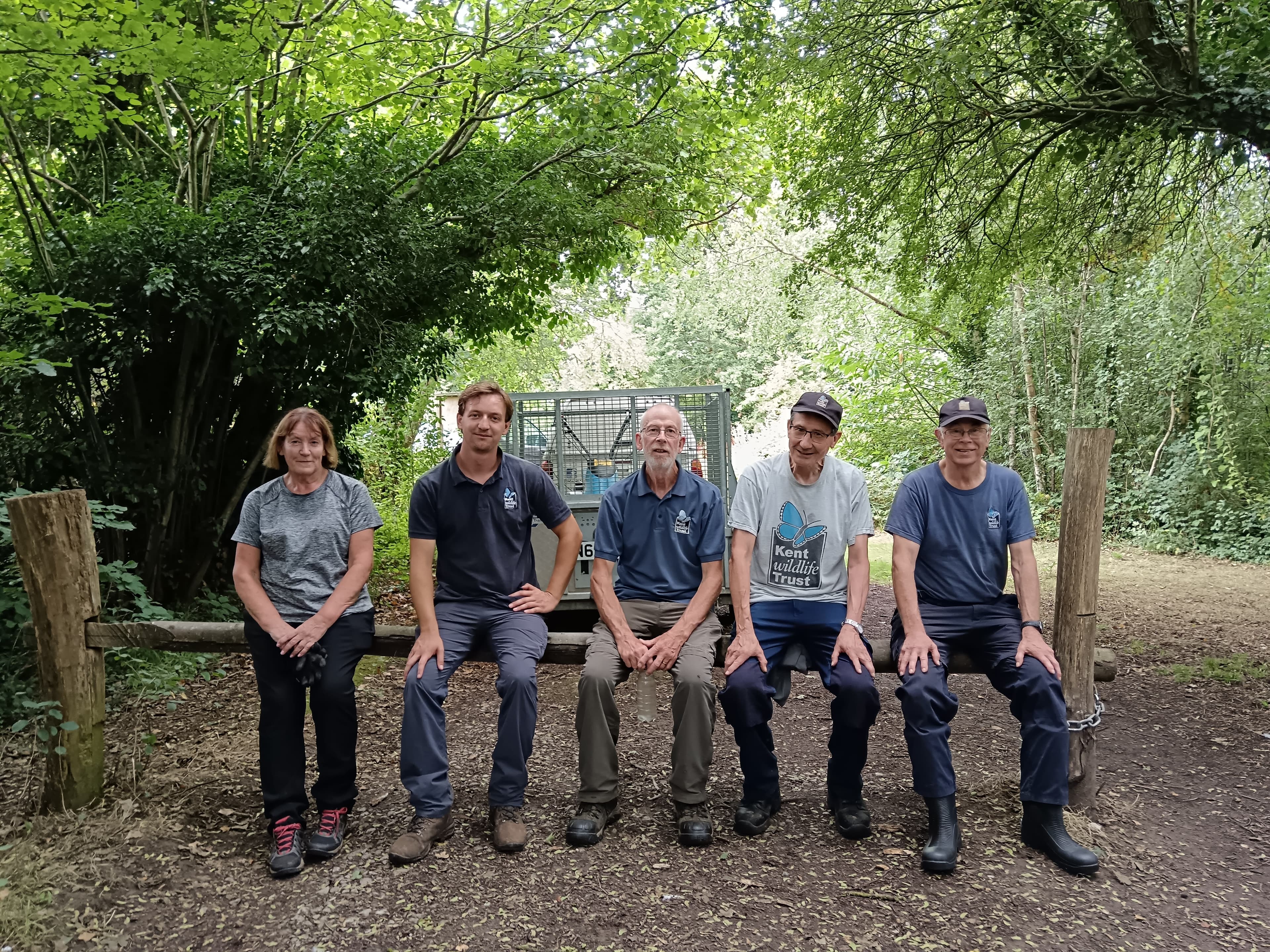 A group of men sitting on top of a wooden bench