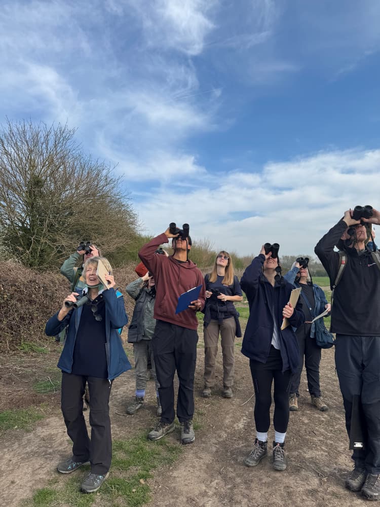 A group of people standing on top of a dirt road