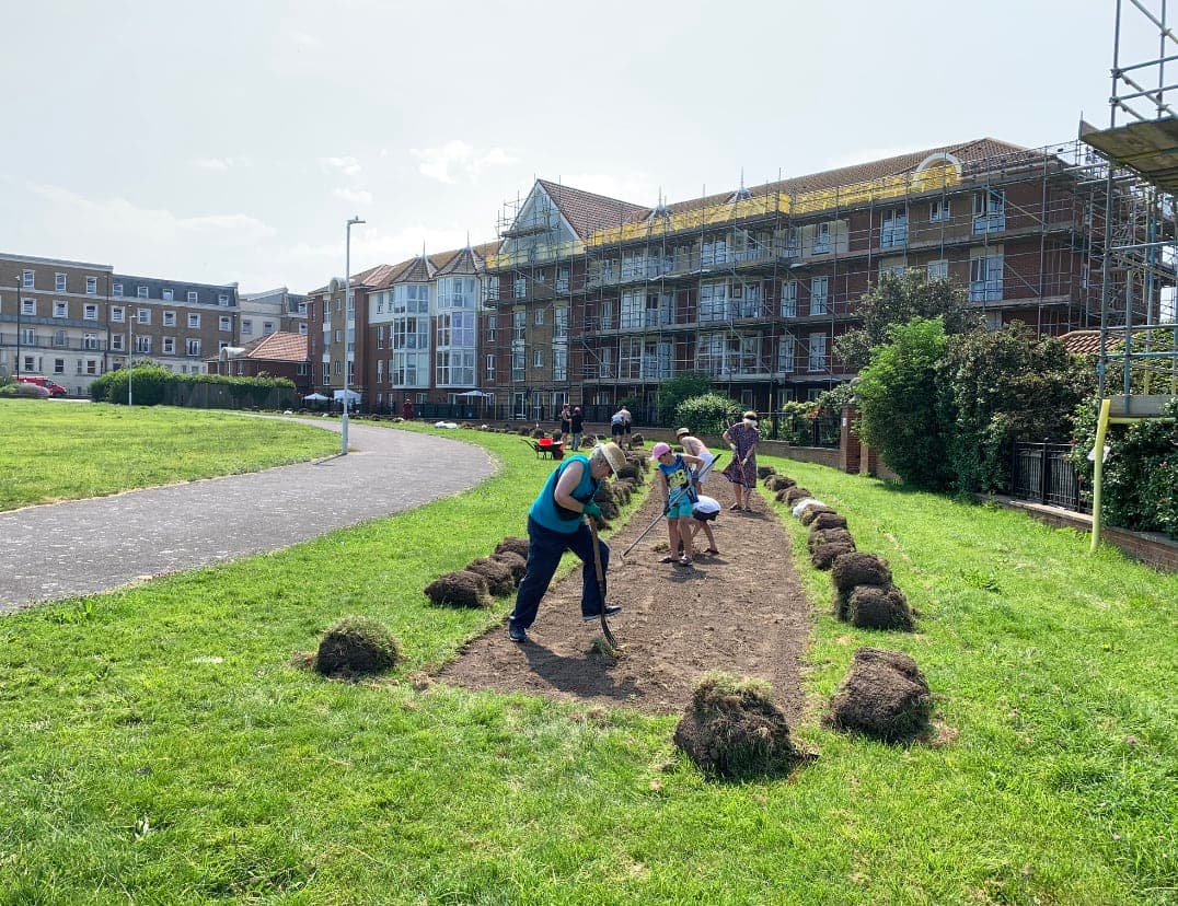 A group of people standing on top of a lush green field