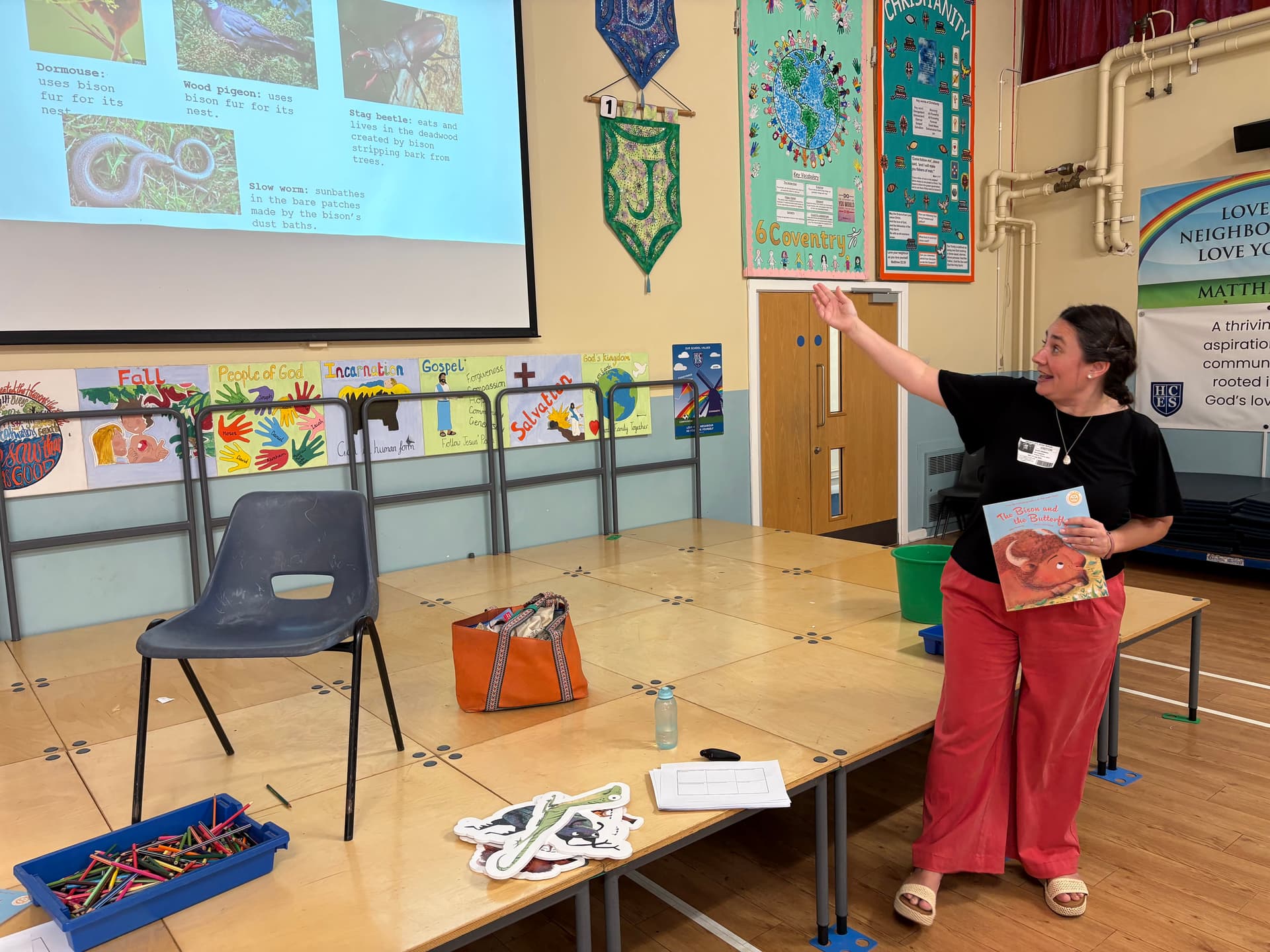 A woman standing in front of a table with a projector screen