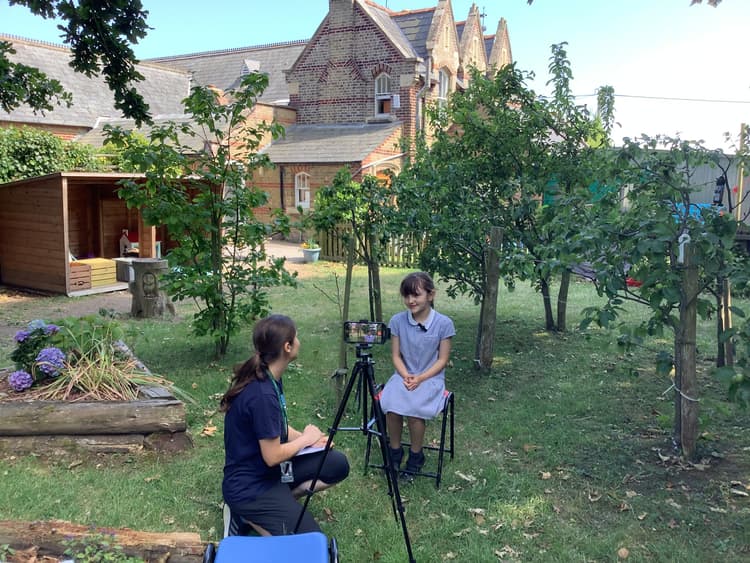 Two people sitting in chairs in a yard