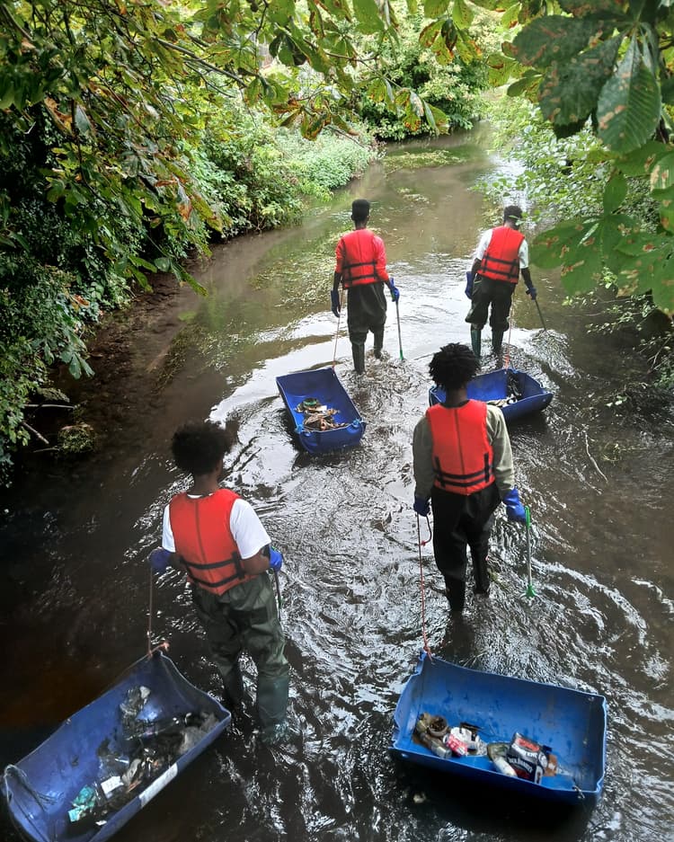 A group of people walking through a river